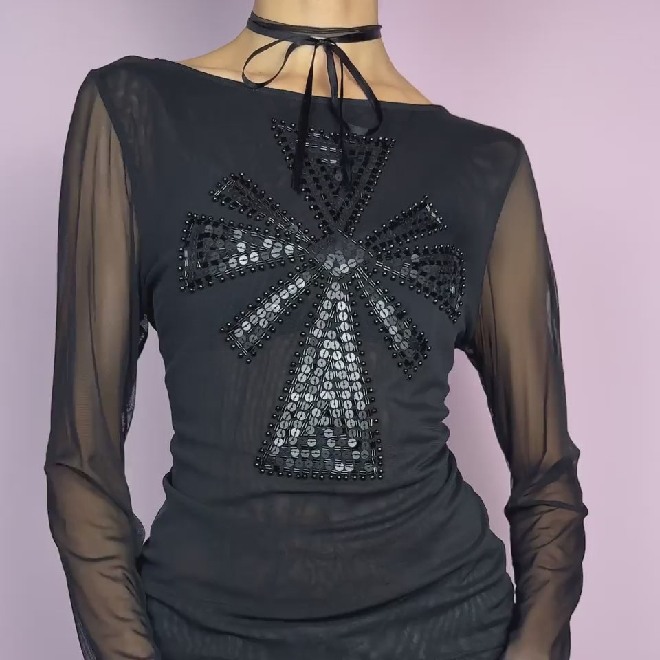 The Y2K Black Embellished Mesh Top is a statement vintage 2000s piece. This sheer top features a bold black sequin and bead embellishment in a striking cross pattern on the front. The lightweight mesh fabric and long sleeves create an alluring see-through effect. Ideal for a night-out look.