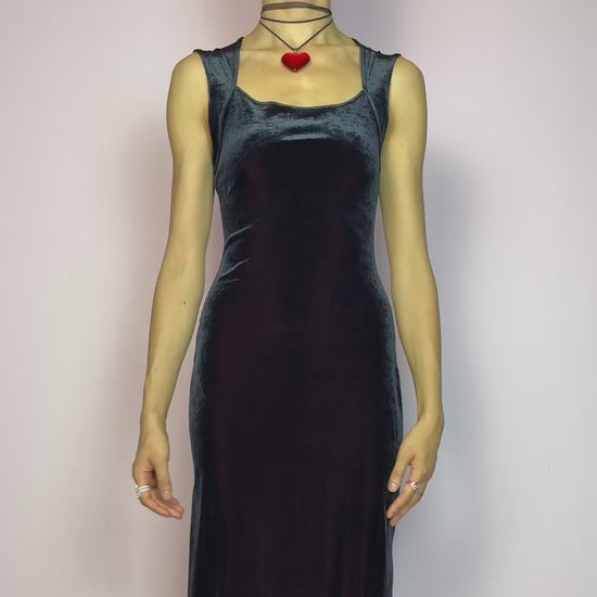 The Vintage 90s Black Velvet Midi Dress is pure elegance with a twist. Crafted from deep black velvet with a maroon undertone, it catches the light with rich, dark burgundy reflections that give it a luxe finish. Features wide straps, a square neckline, and a body-hugging midi silhouette that flatters and elongates. Soft and stretchy for comfort, yet bold and dramatic for gothic, romantic, or night-out looks. A subtly striking piece that stands out in movement and moonlight. Made in Europe.
