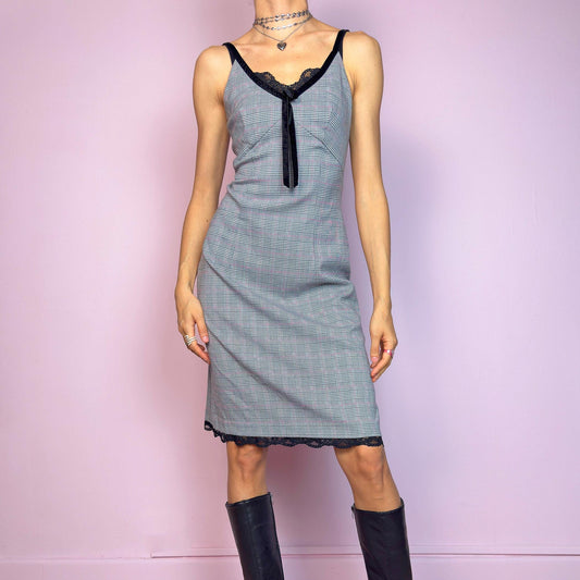 This vintage 2000s slip dress features a gray plaid print with black lace trim and a velvet bow at the bust. It has adjustable straps, a hidden back zipper, mid-length hem, and subtle stretch. The lingerie-inspired cut blends romantic and preppy codes, perfect for summer or layered transitions. A sleek office-core silhouette with soft edge—equal parts elegance and vintage 2000s attitude. Excellent vintage condition.