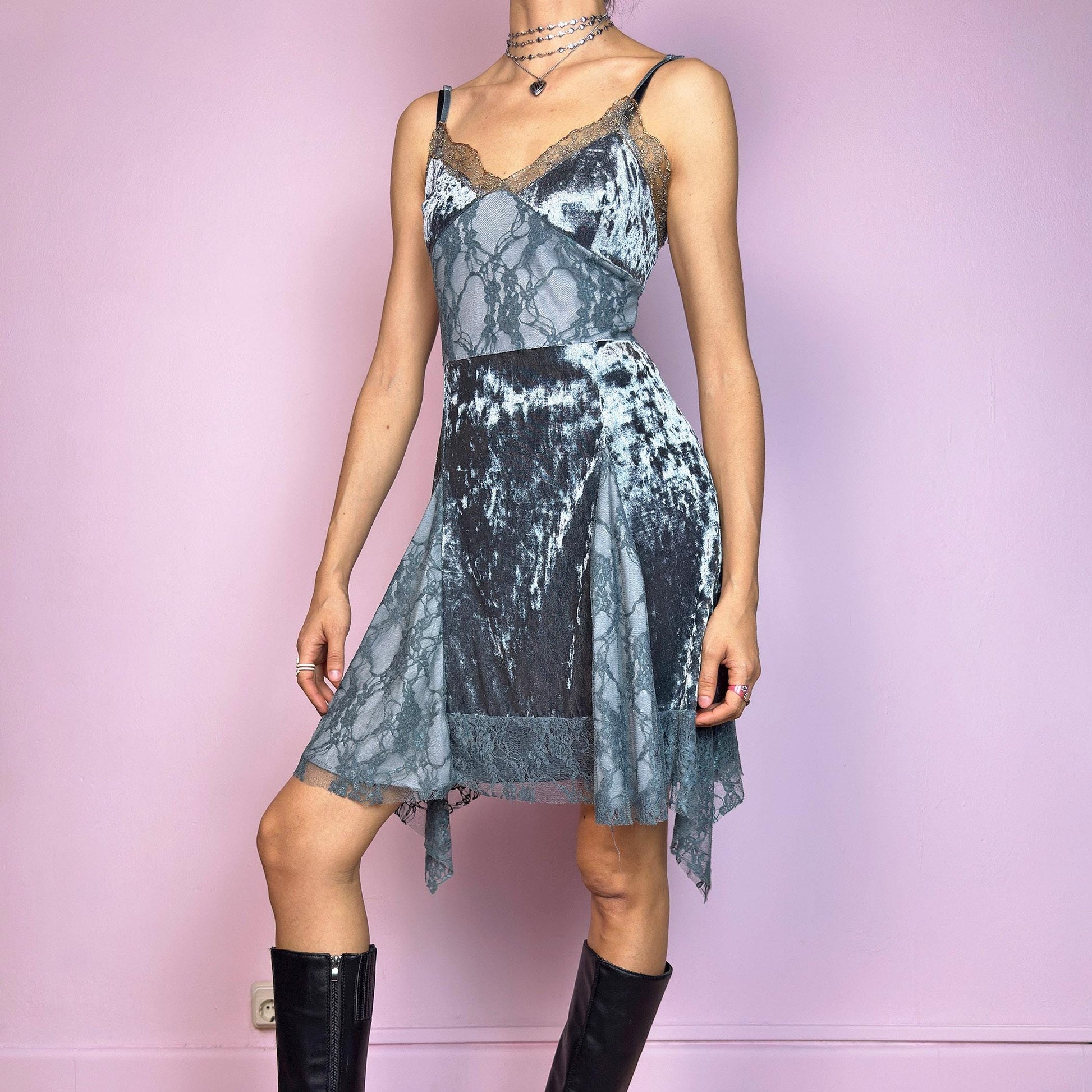 This vintage 2000s stretchy slip dress is cut from cool grey velvet with sheer lace panels and scalloped trim. It features a V-neckline, thin adjustable straps, and an asymmetric handkerchief hem. The paneled construction sculpts the waist and includes a hidden side zipper. Perfect for summer. A romantic Y2K piece with whimsical fairycore undertones. Great vintage condition.