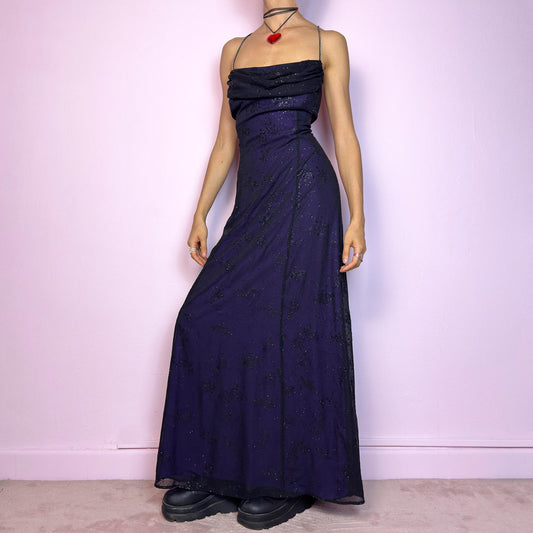 Step into the night in this breathtaking vintage 90s formal black glitter maxi dress. Crafted from a deep purple base with a sheer black overlay, it features all-over subtle glitter details that catch the light with every move. The draped cowl neckline adds soft elegance, while the delicate spaghetti straps are adorned with shimmering rhinestones for that extra sparkle. Designed with a flattering fit and a back zipper closure for ease and shape. A rare celestial piece – ideal for prom.