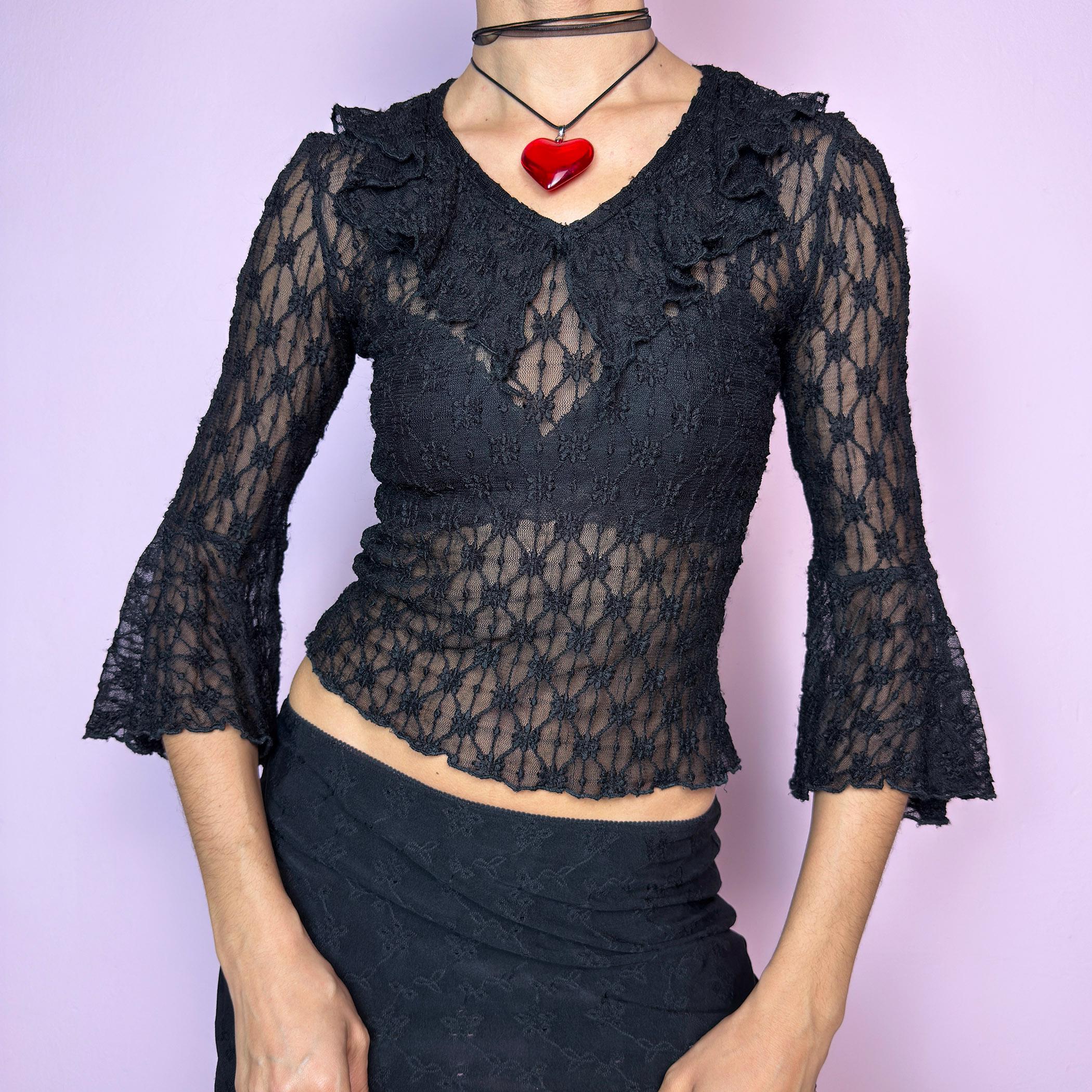 The Y2K Lace Ruffle Black Top is a vintage 2000s sheer black lace top featuring a fitted silhouette, mini ruffle details along the neckline, and flared three-quarter bell sleeves. The textured floral lace adds a romantic gothic touch, perfect for layering or wearing on its own. Ideal for summer night looks and festival outfits. Great vintage condition. adult world shop