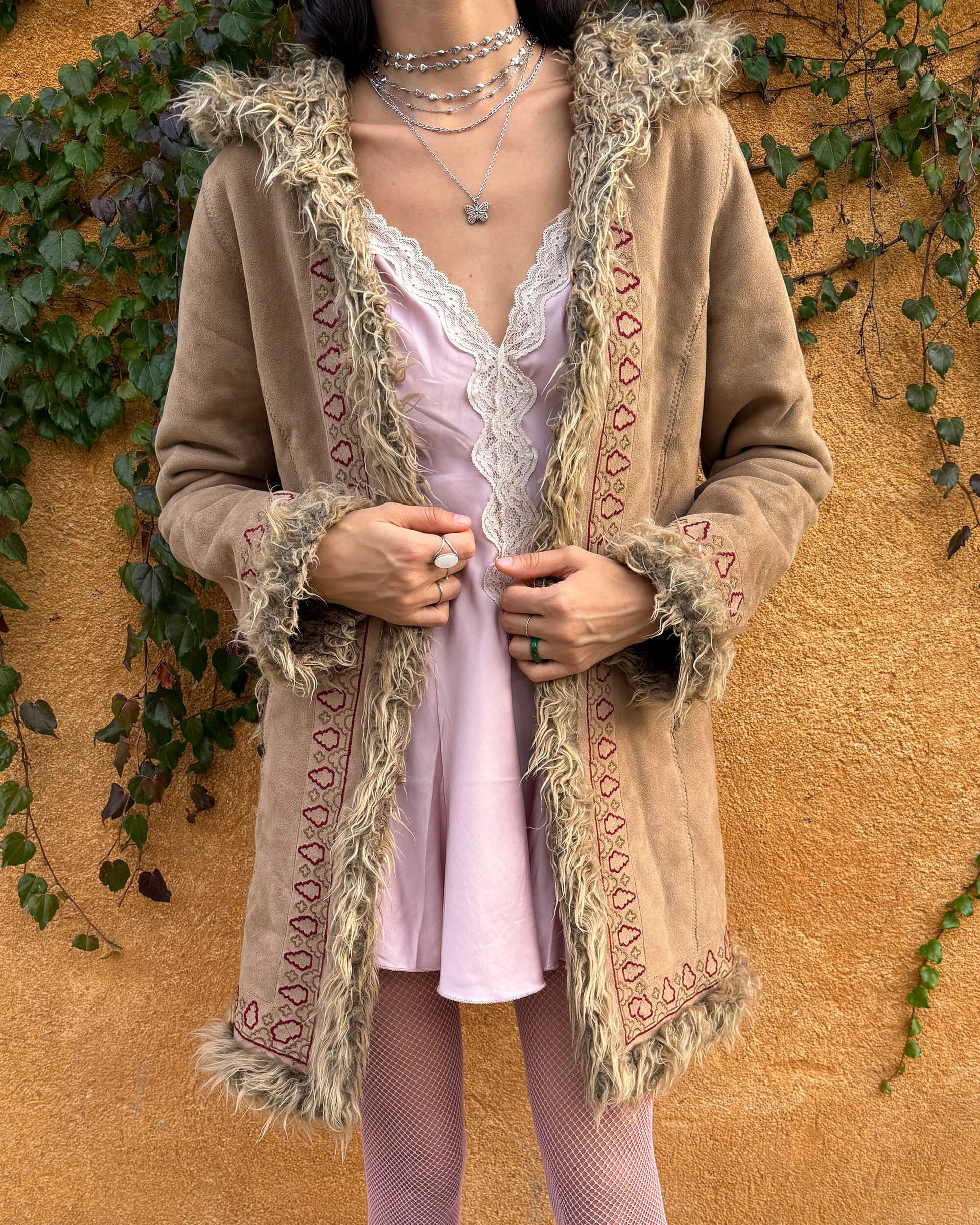 Vintage 2000s beige Penny Lane coat with a 70s boho hippie influence, featuring a hood, faux fur lining and faux fur cuffs. Designed with hook closures, front pockets, and red and brown embroidered details that give it a charming Afghan-inspired look. Warm, cozy, and super cute for winter styling, perfect as an iconic Y2K cold-weather essential. Great vintage condition.